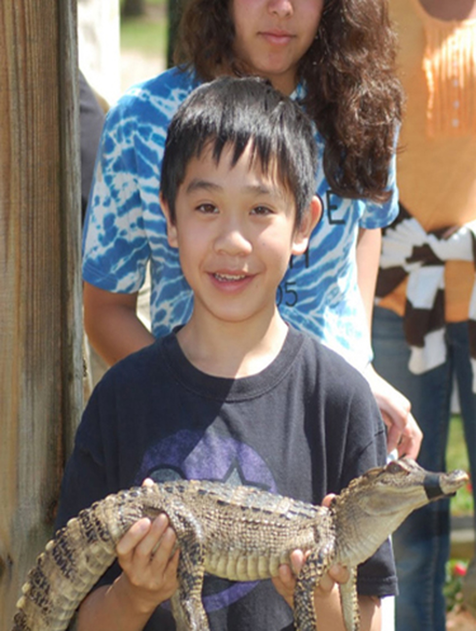 A boy holding baby crocodial